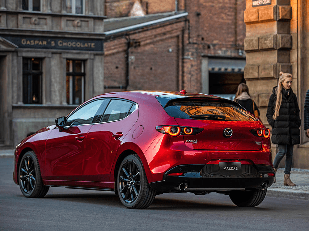 Vue 3/4 arrière du Mazda Mazda3 Sport 2024 en ville.