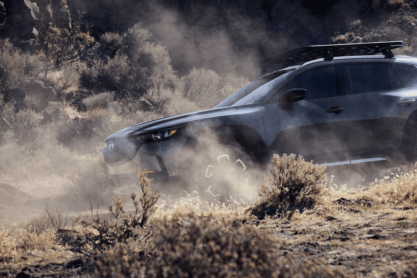 The 2025 Mazda CX-50 driving on an off-road path.