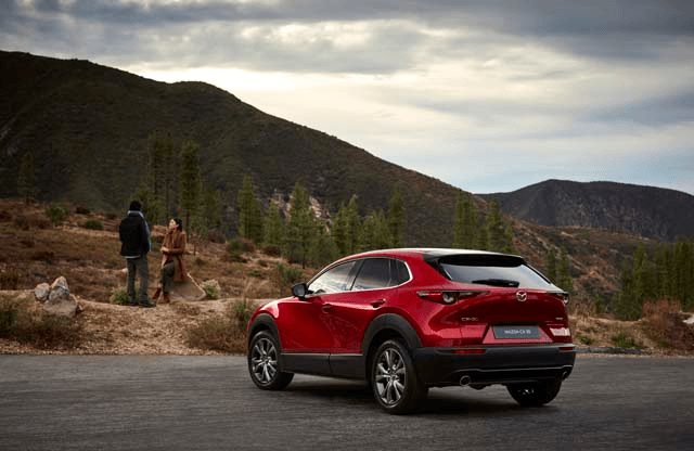 Mazda CX-30 2020 rouge, vu de dos, un peu de biais, en forêt