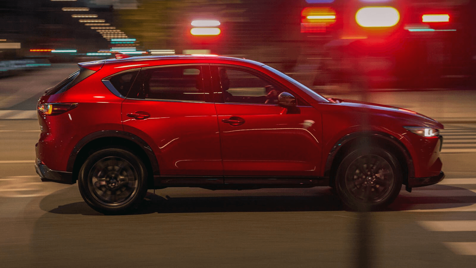 Vue latérale du Mazda CX-5 2025 sur la route en ville.