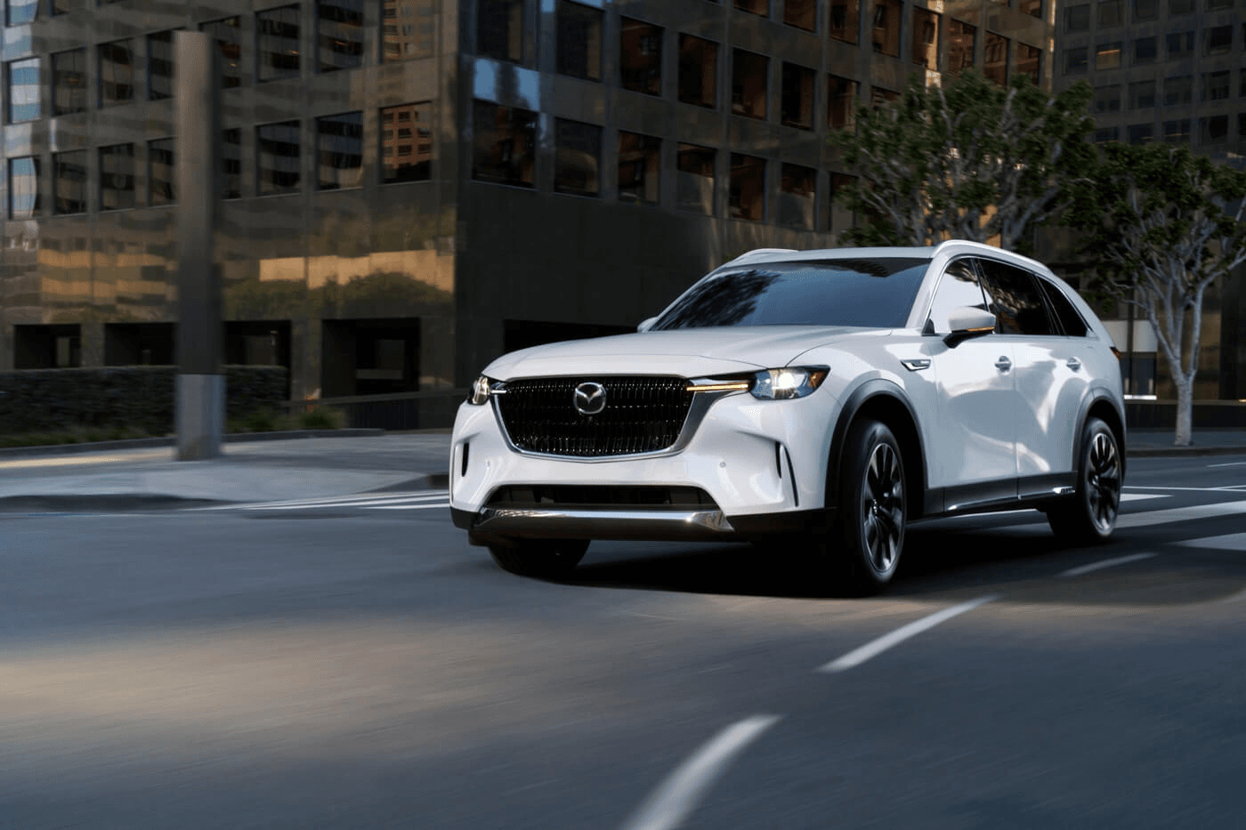 3/4 front view of the 2025 Mazda CX-90 PHEV driving in the city.